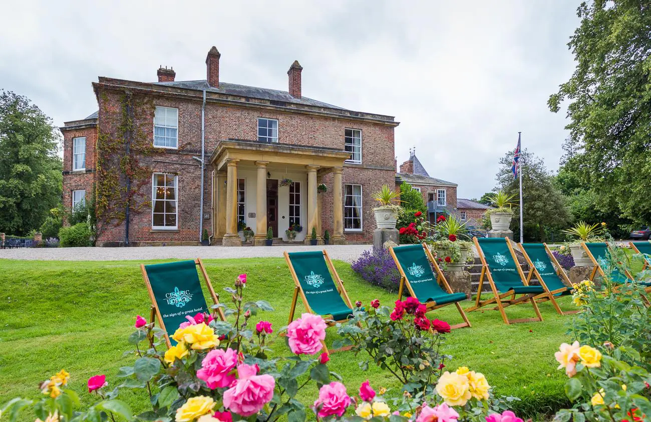 A large house with lawn chairs in front of it, perfect for wedding planning or hosting a wedding in the UK.