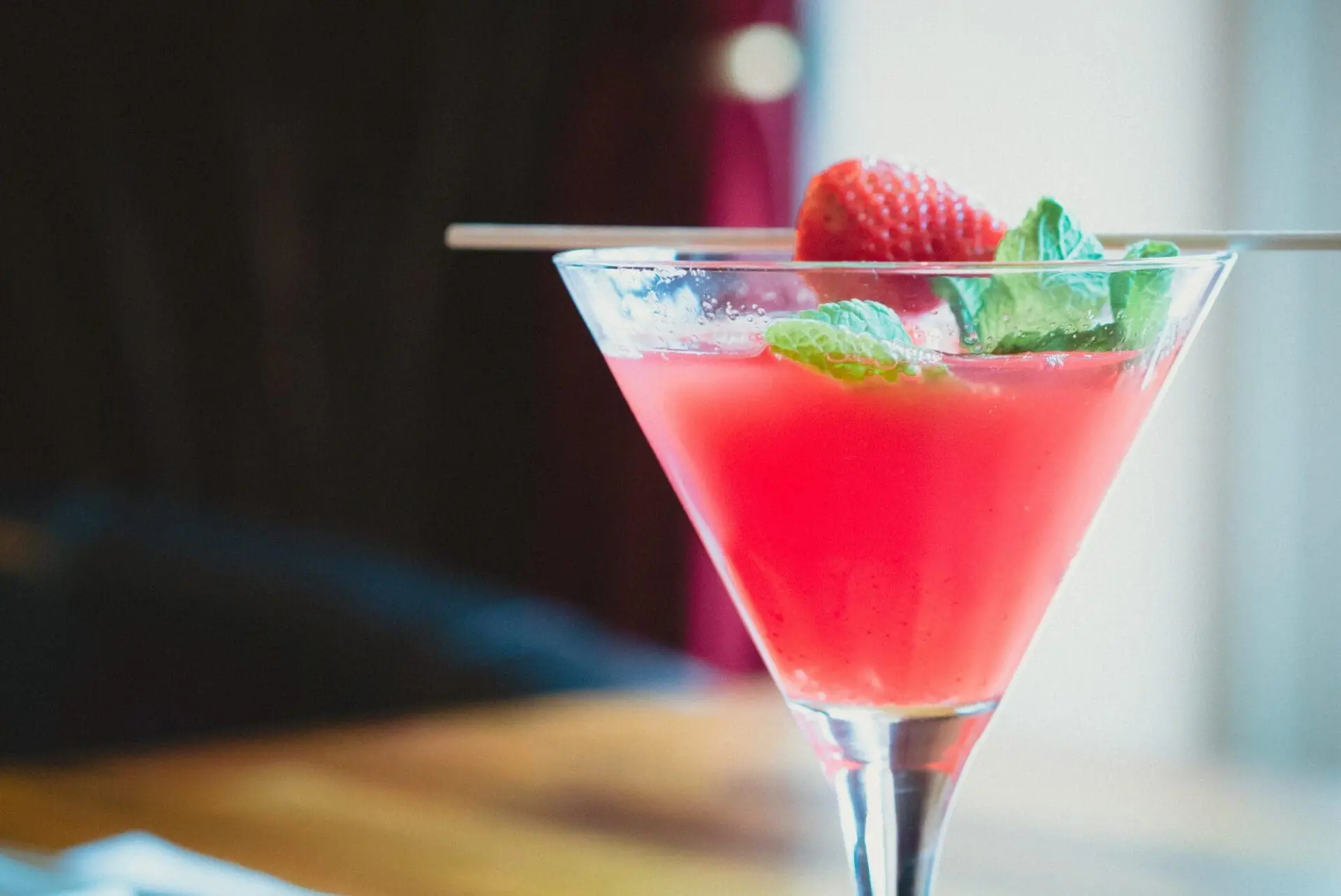 A festive martini with a refined strawberry and mint garnish, perfect for wedding receptions.