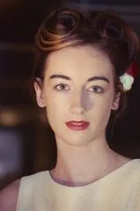 A woman with red hair and a flower in her hair showcasing wedding elegance.