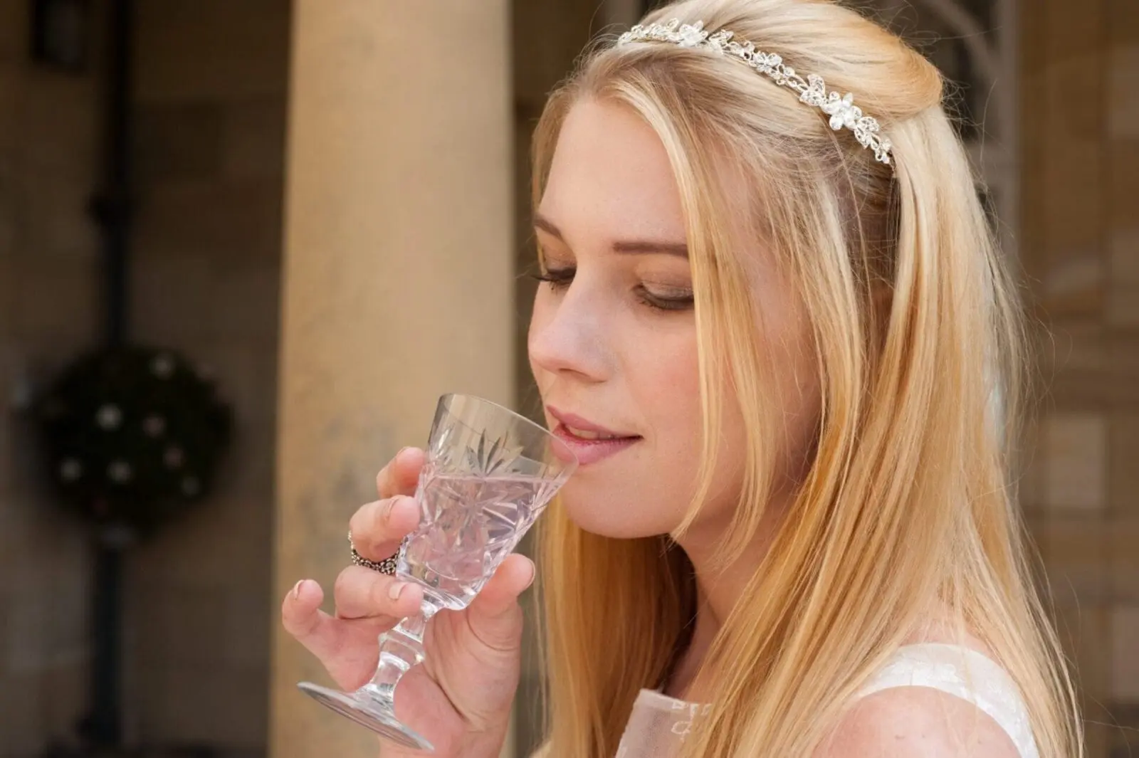 A young woman drinking water from a glass while planning her wedding.