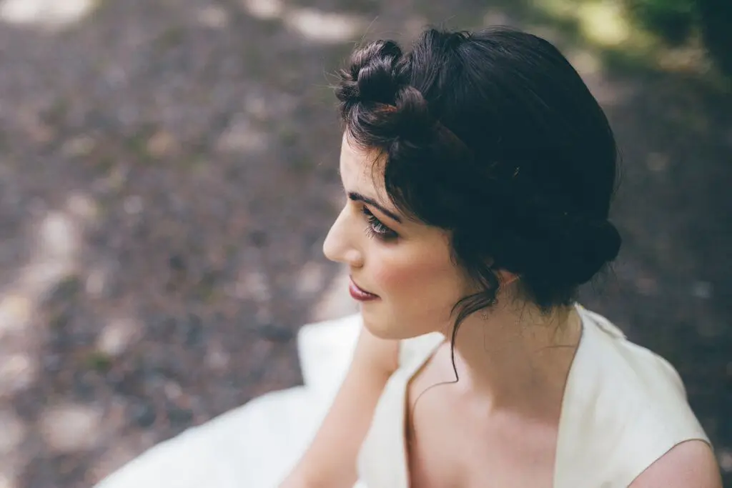 A bride in a white dress planning her wedding, sitting on the ground.