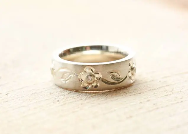 A silver ring adorned with delicate flowers, perfect for a wedding.