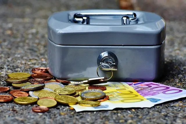 A money box with coins and a key on the ground, suitable for wedding planning or a wedding business.
