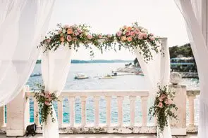 A stunning wedding ceremony set up on a balcony overlooking the sea, meticulously planned by experienced wedding professionals in the UK.