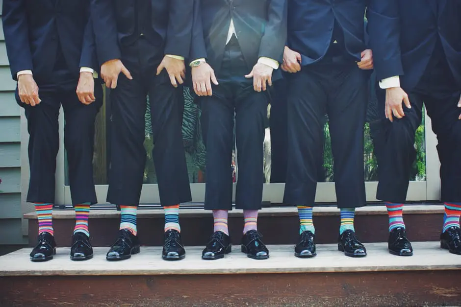 A group of groomsmen wearing colorful socks at a wedding in the UK.