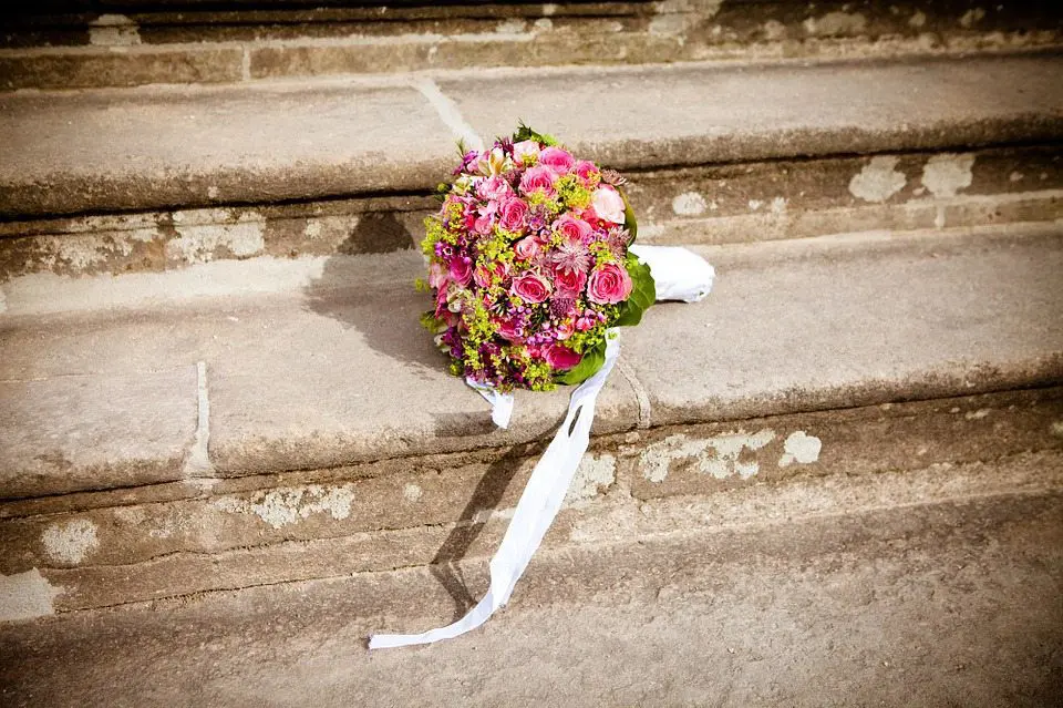 A bouquet of flowers sits on the steps of a wedding planning company building.