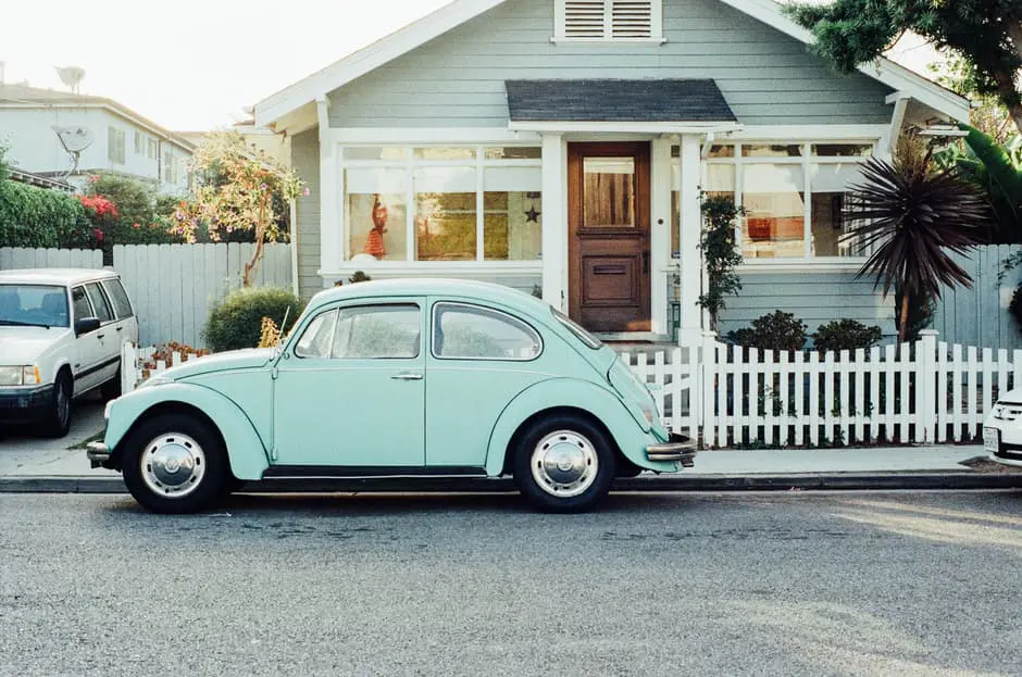 A white house with a VW Beetle parked in front, perfect for wedding planning businesses in the UK.