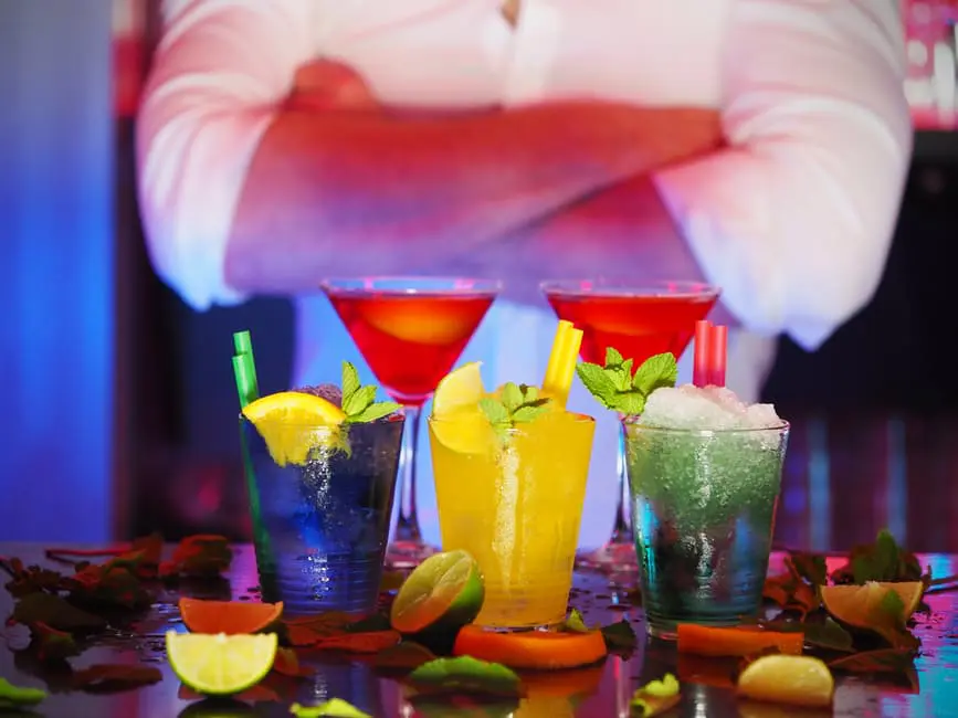 A bartender is serving a delightful array of colorful drinks at a wedding event.