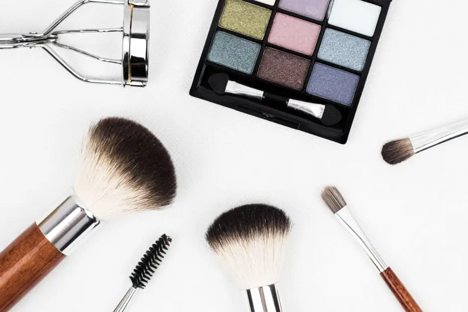 Wedding makeup brushes and cosmetics on a white background.