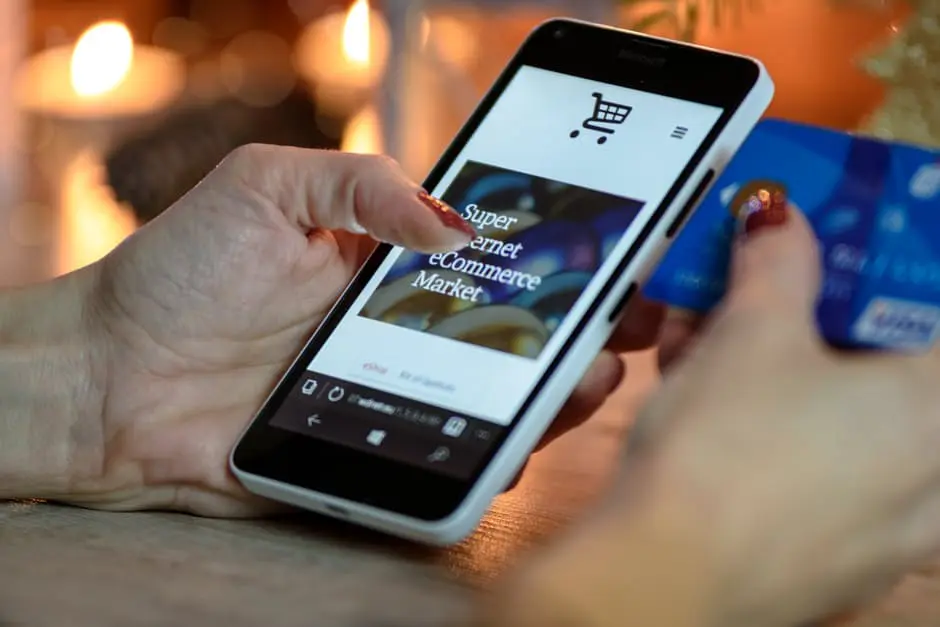 A woman planning her wedding, holding a credit card on a smartphone.