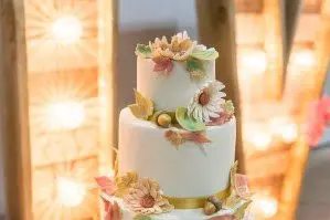 A beautifully adorned wedding cake featuring flowers and leaves, the perfect centerpiece for your dream wedding.