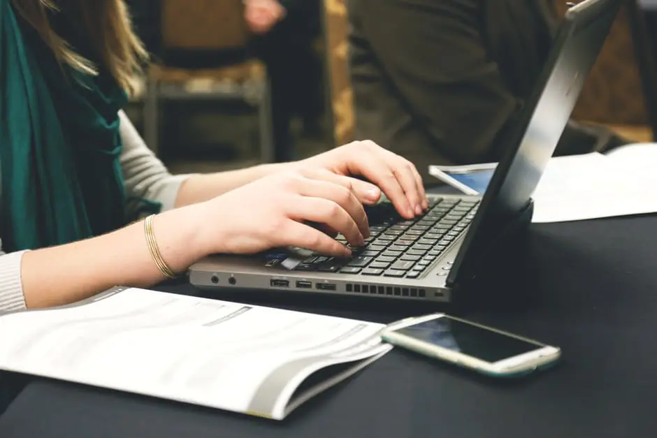 A woman planning a wedding typing on a laptop at a conference.