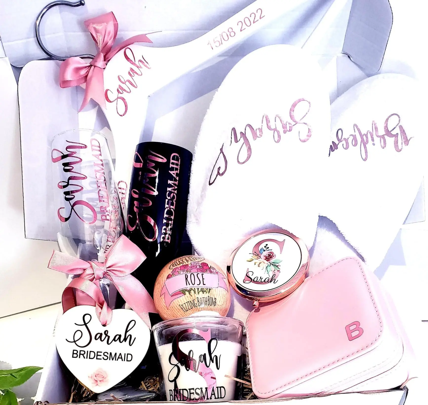 A pink gift box with various items in it.
