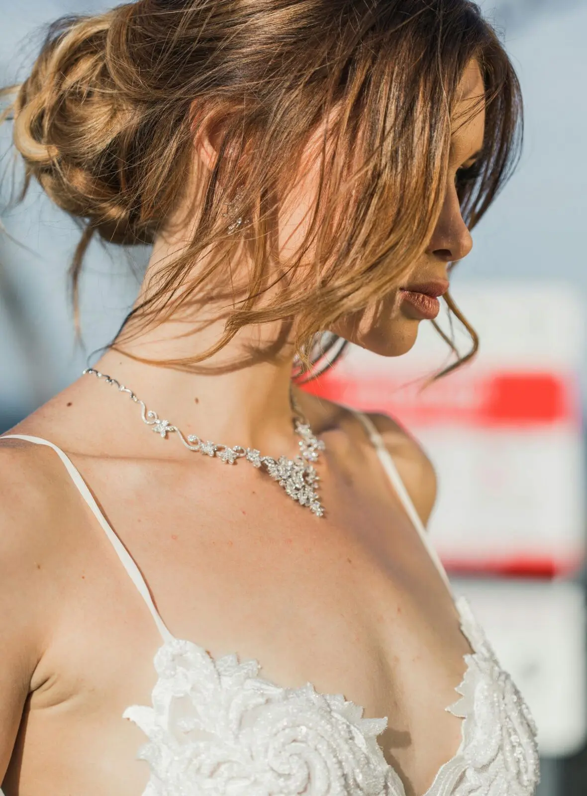 A woman wearing a white wedding dress and a necklace.