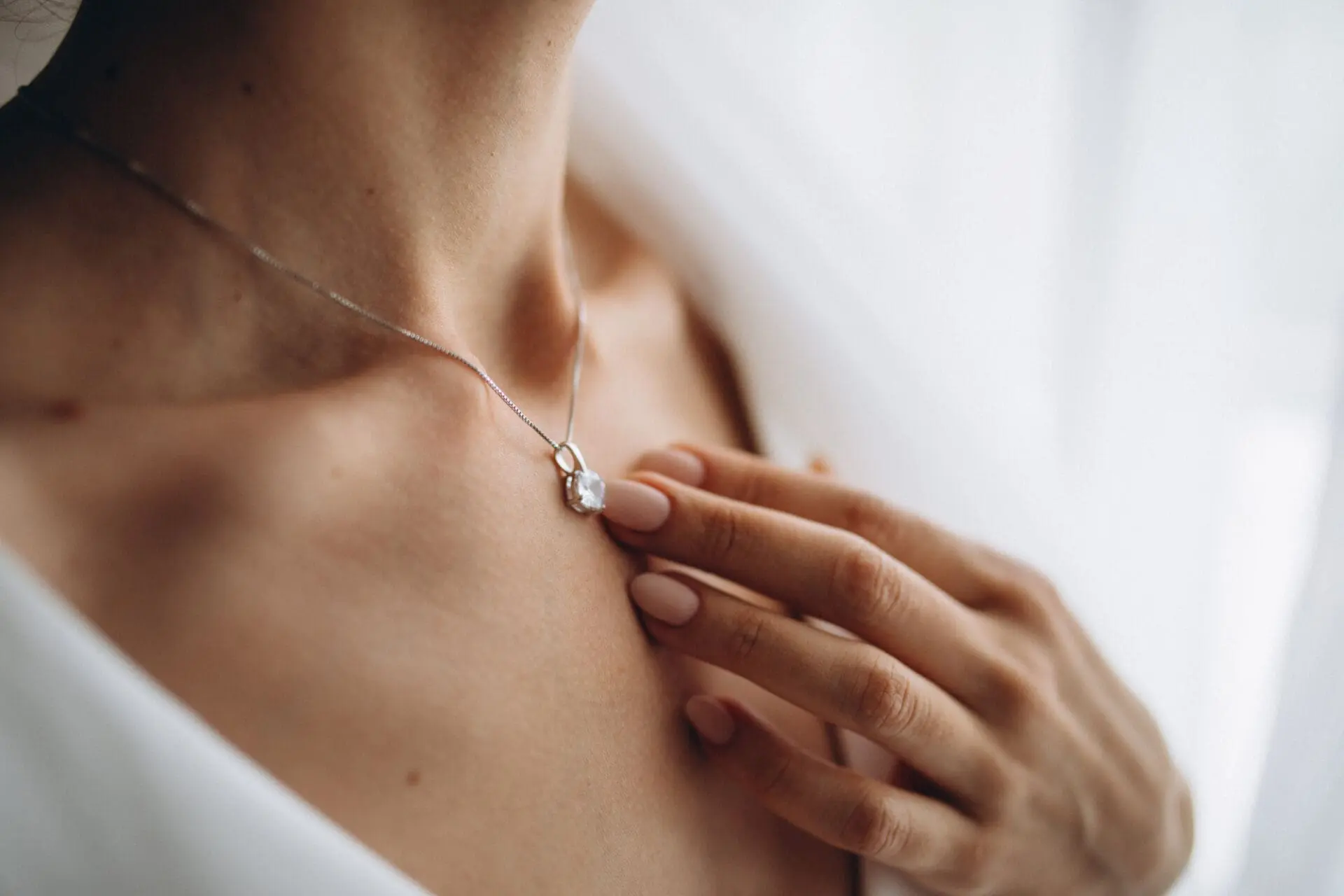 A woman wearing trendy wedding jewellery of a delicate necklace on her chest.
