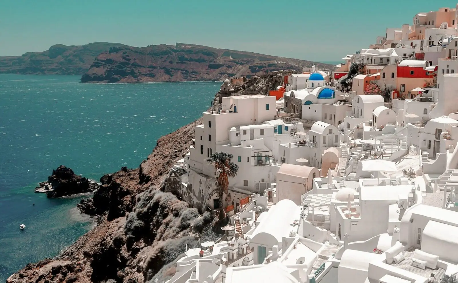 white buildings on a sunny cliff with the blue sea.