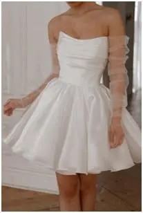 Short white wedding gown with tulle gloves made of net.