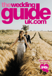 A couple walks through a wheat field on the cover of "The Wedding Guide UK.com," encapsulating the romance and serenity that inspires perfect wedding planning.