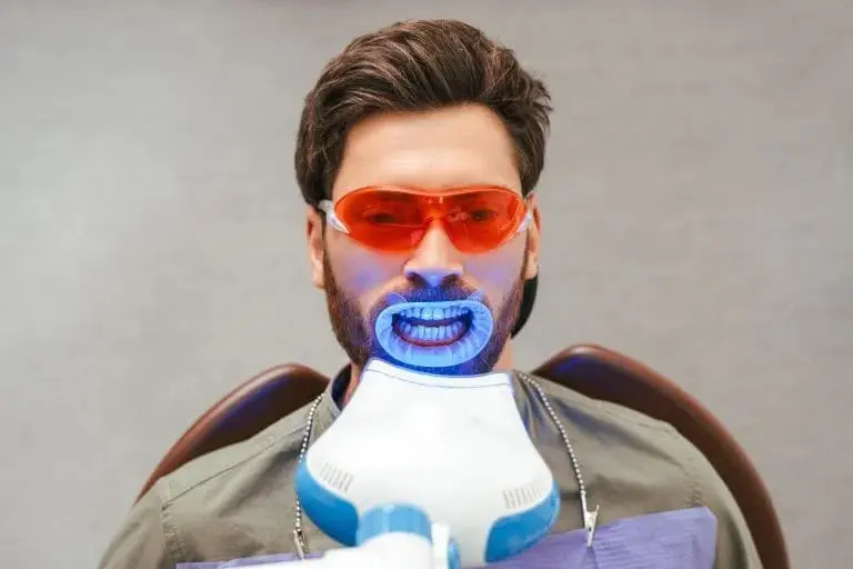 A picture of a person getting a teeth whitening treatment for a perfect wedding smile.