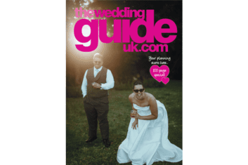A bride in sunglasses and a strapless dress crouches on the grass with a drink, while a groom stands nearby. "The Wedding Guide UK" magazine cover text is overlaid.