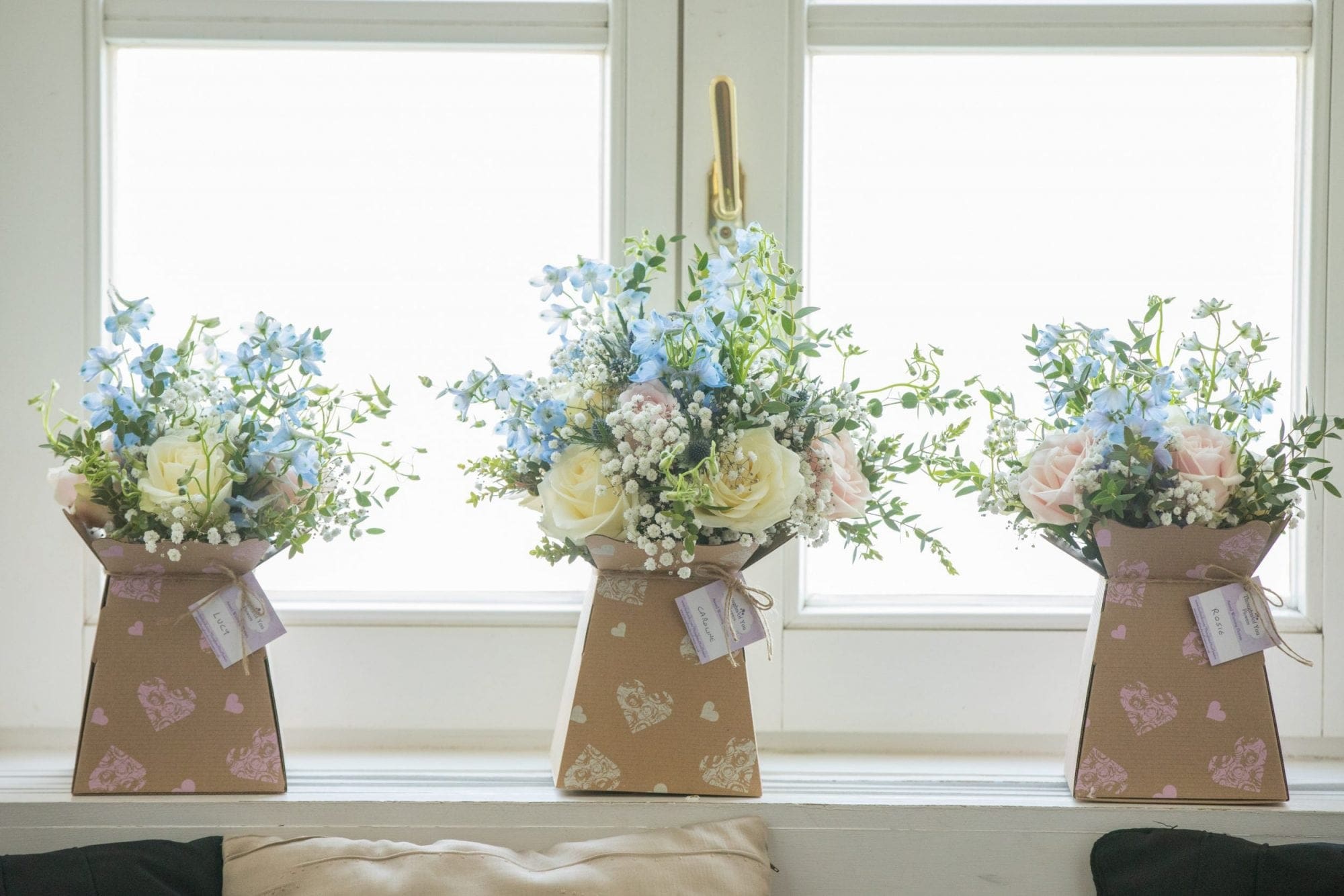 Three vases of flowers adorning a window sill for a beautiful wedding in the UK.