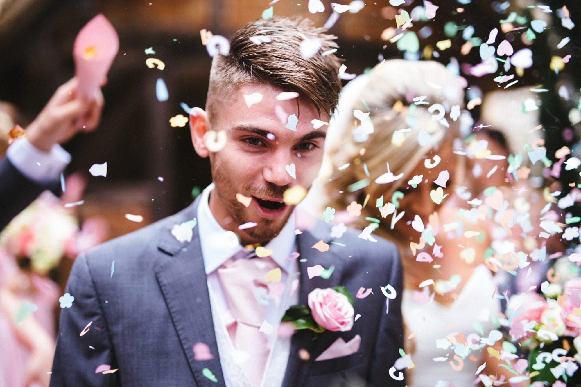 Wedding confetti being thrown at a bride and groom during their wedding celebration.