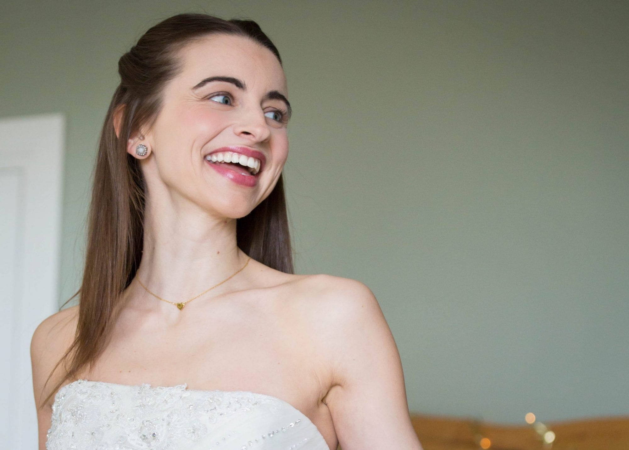 A bride is laughing in her wedding dress at her joyful UK wedding.