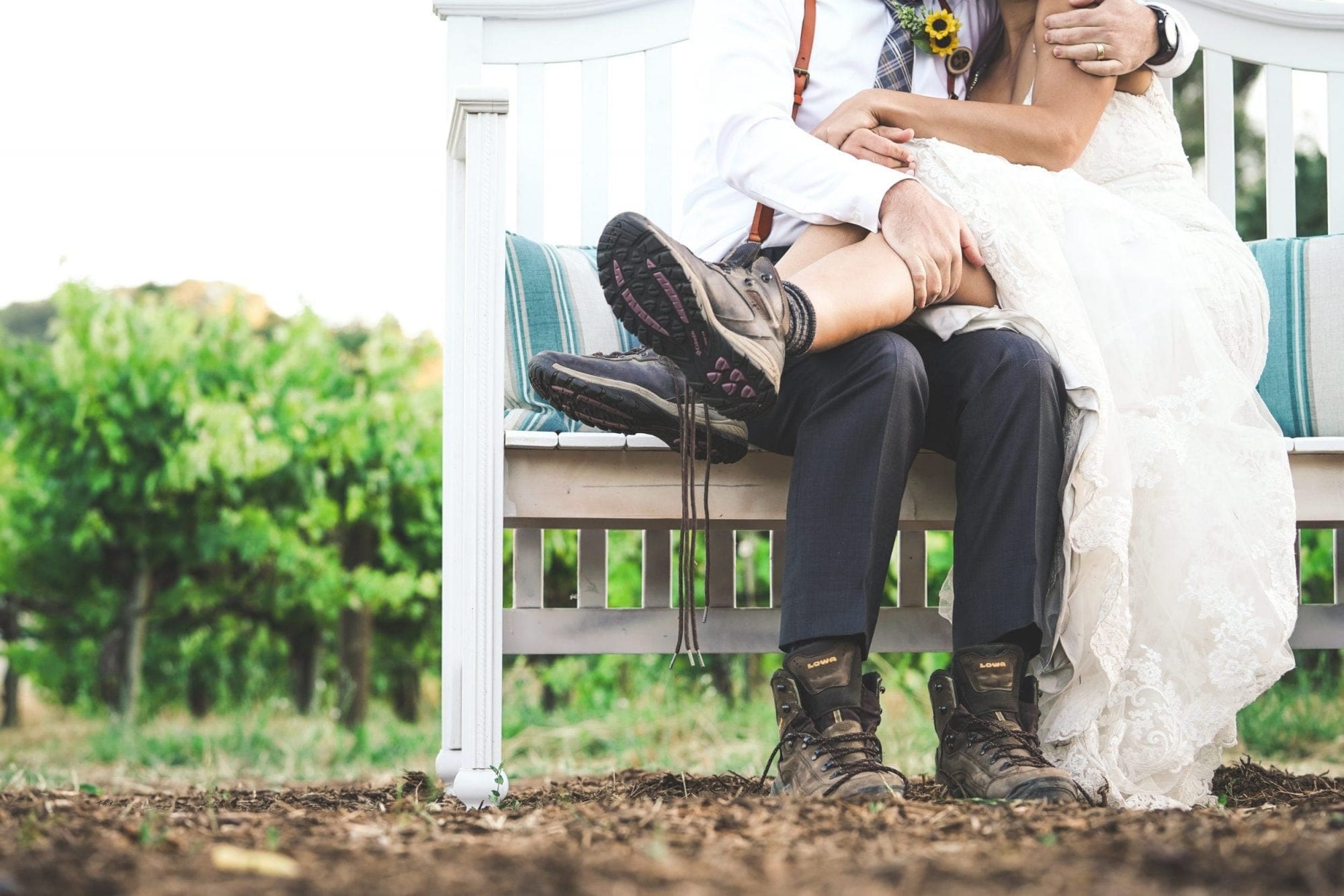 A bride and groom enjoying a serene moment on a bench in a beautiful vineyard, envisioning their dream wedding day.