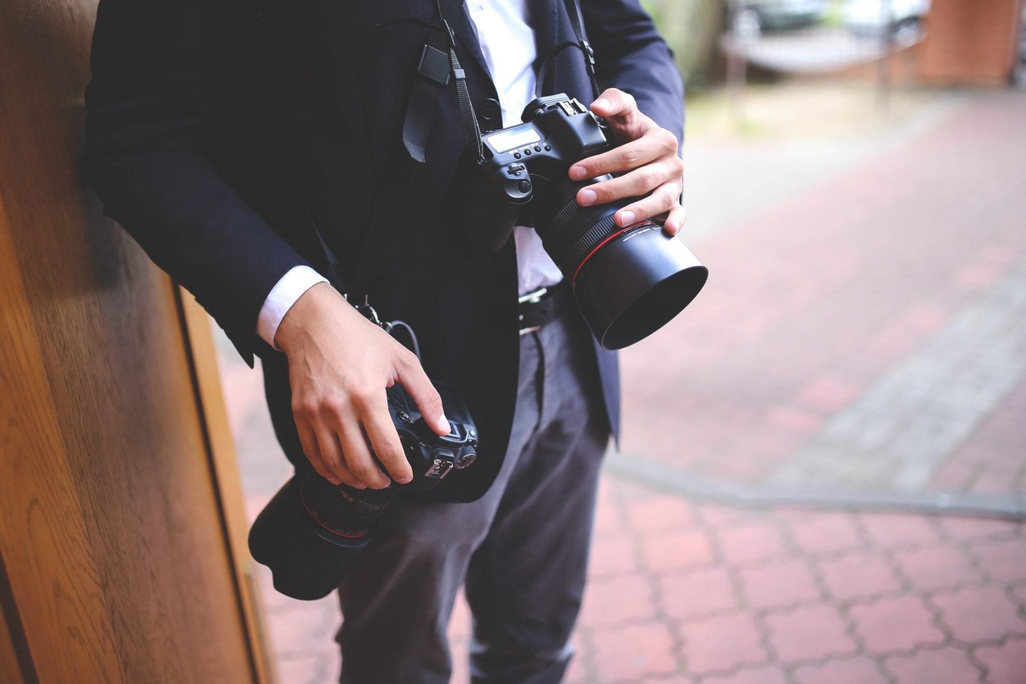A man in a suit capturing unforgettable moments with his camera during a wedding.