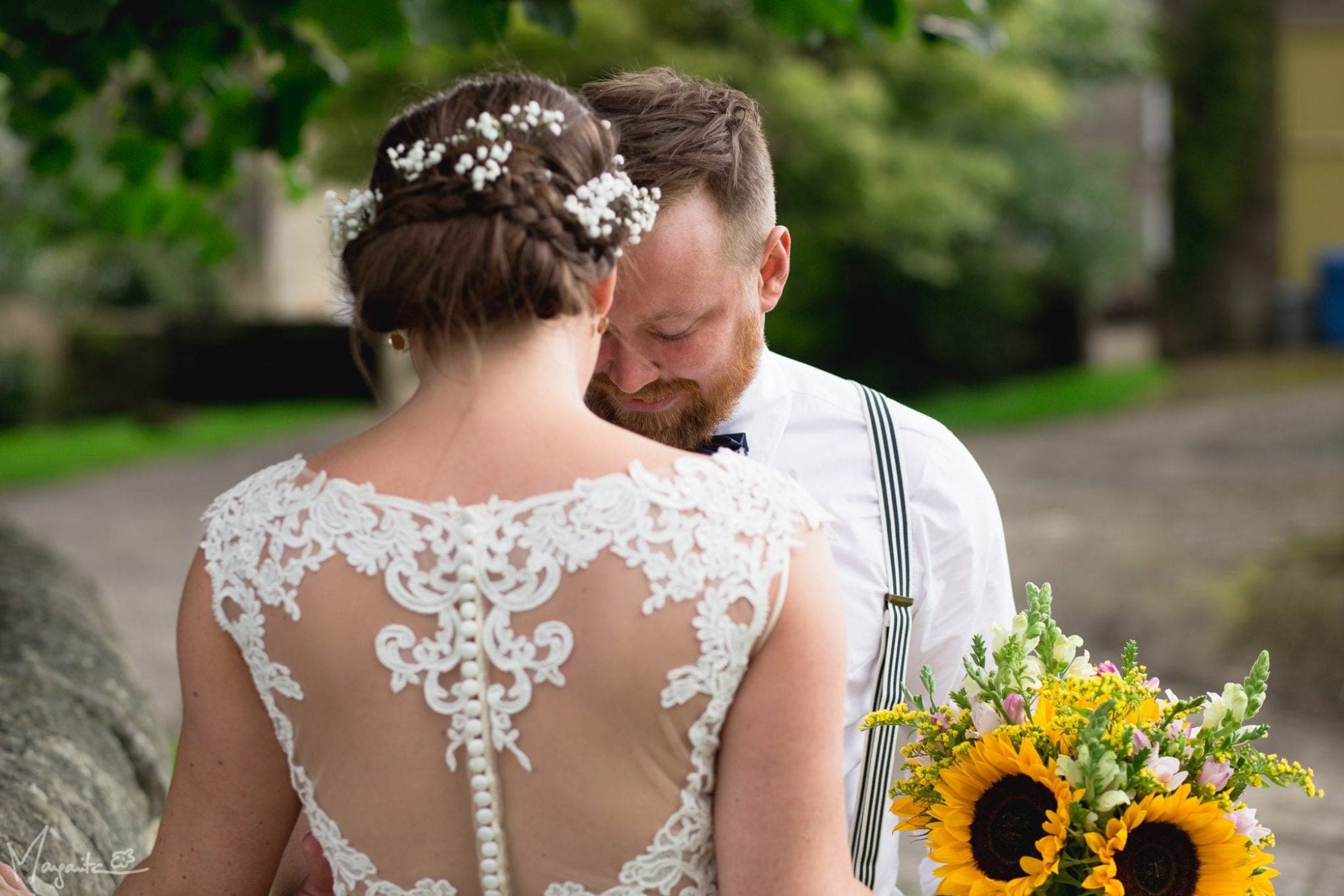 A bride and groom, accompanied by beautiful sunflowers, standing next to each other as they celebrate their wedding day in the UK.