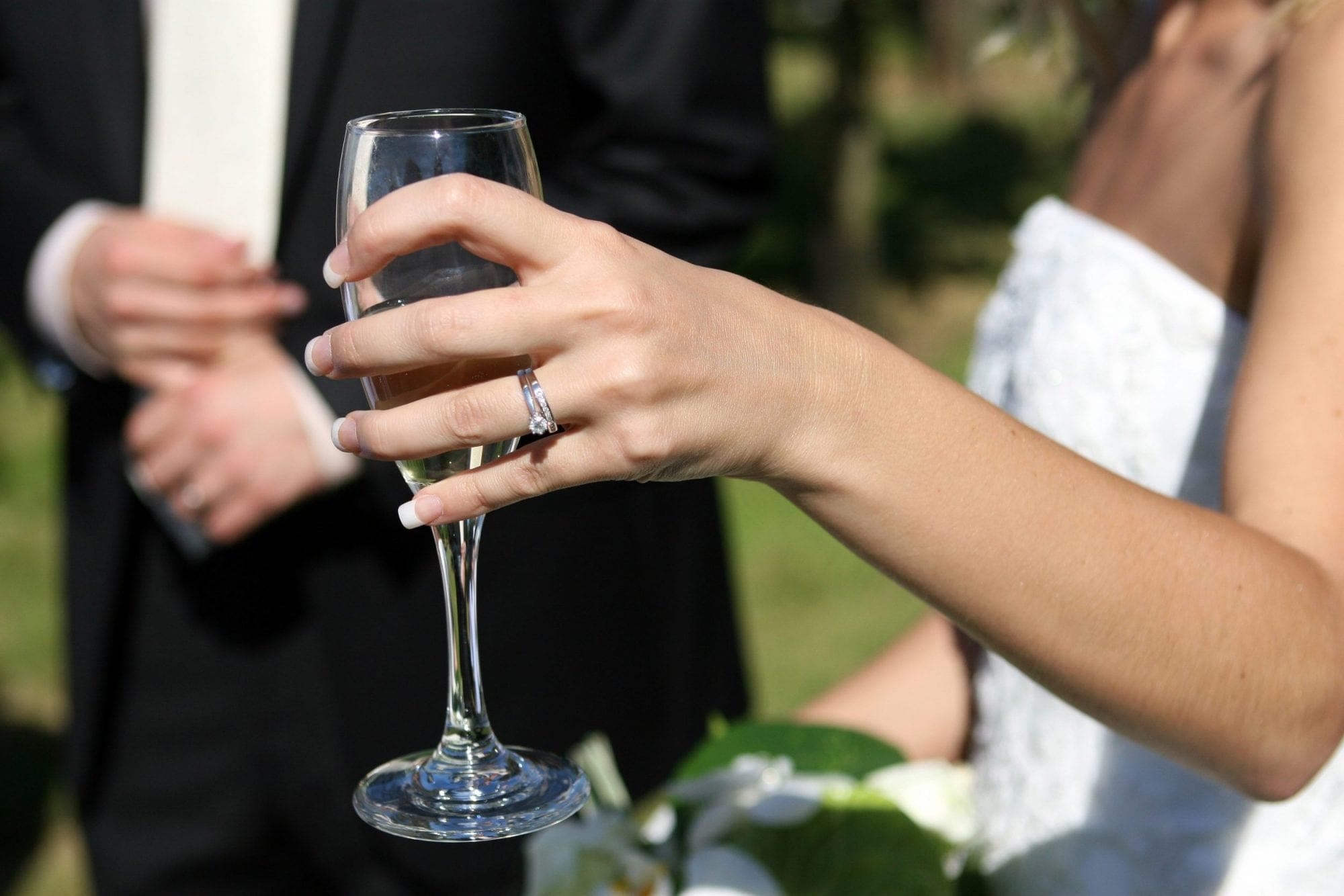 A bride and groom celebrating with a glass of champagne at their wedding.